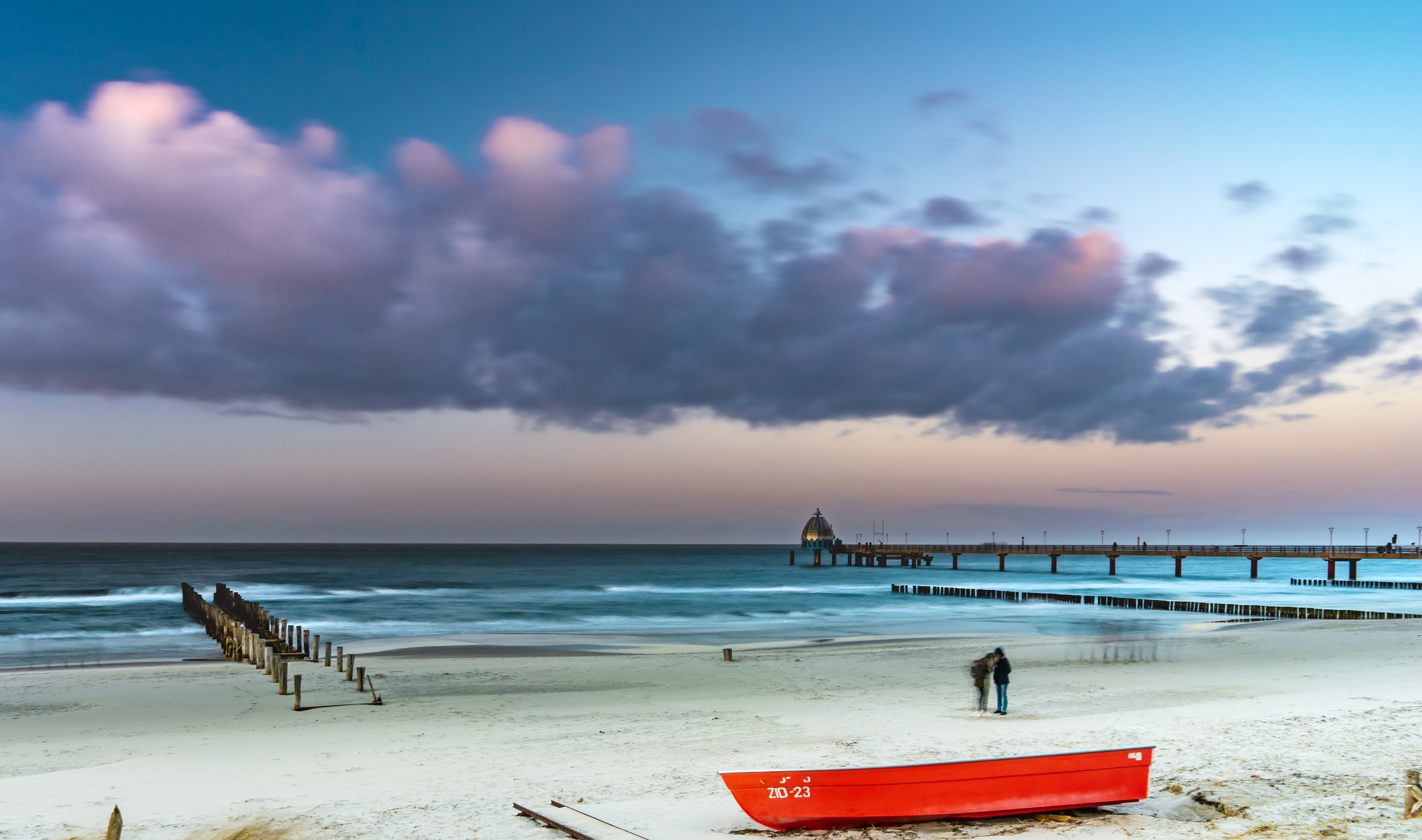 Ostseestrand mit Seebrücke und rotem Boot